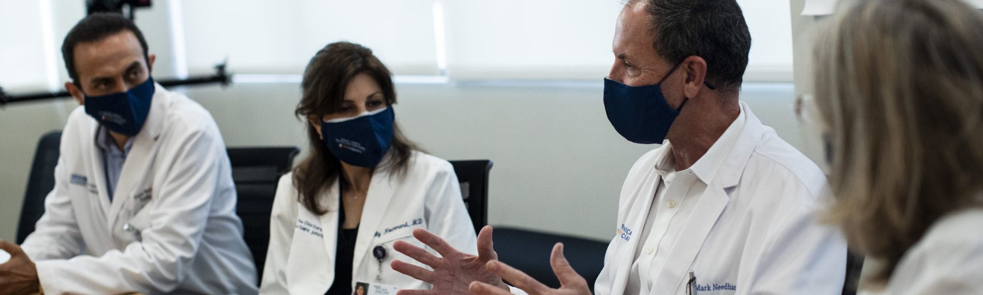 Four doctors in a conference room in a discussion