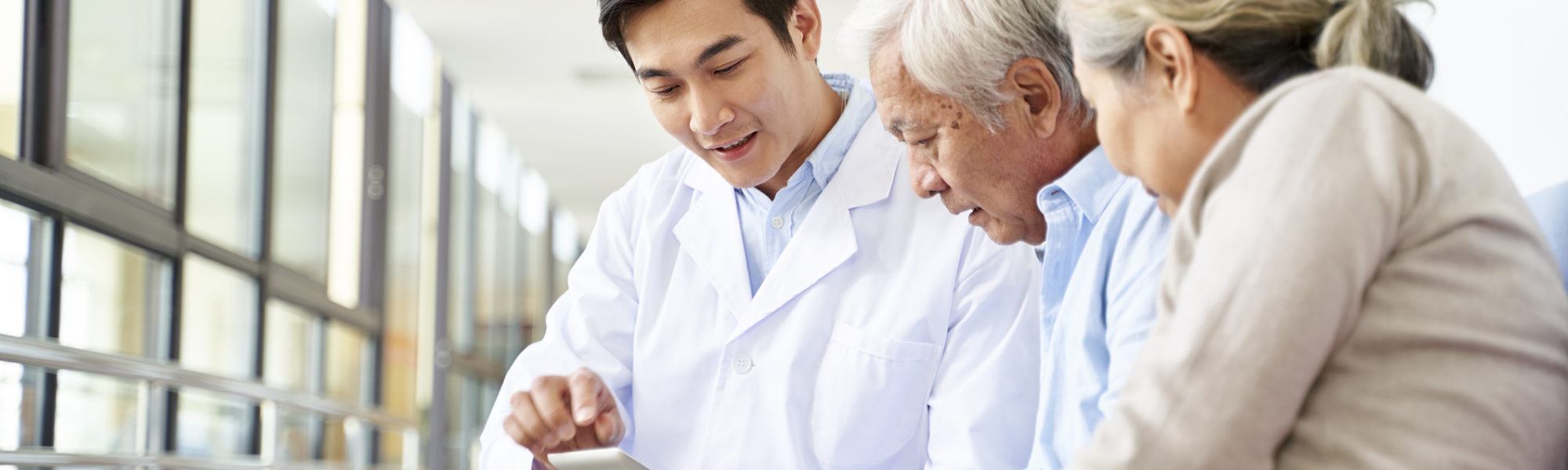 young asian doctor explaining test result to senior patient